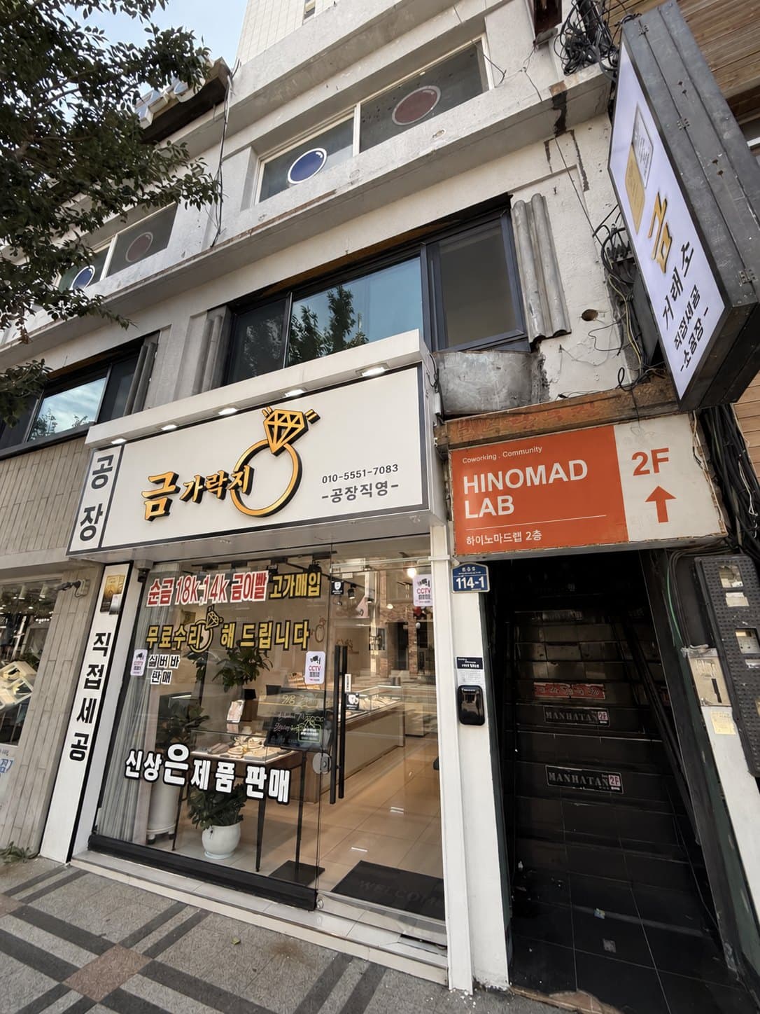 주황색 HINOMAD LAB 2F 간판이 붙은 건물 입구